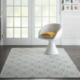 Living room scene with Nourison Aruba Light Blue Cream Beach Area Rug, white chair, wood floors, and natural light.