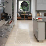 Modern kitchen with stainless steel appliances and Nourison Care Free Beige runner rug.