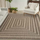 Living room scene with a Nourison Tulum Brown Outdoor Area Rug featuring a geometric square pattern.