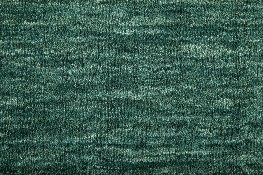 Close-up of the textured, hand woven Feizy Luna Modern Solid Area Rug in green and white wool and cotton. Texture