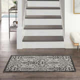 Entryway with Nourison Country Side Ivory/Charcoal rug on dark wood floors, stairs, and white bench.