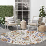 Serene patio with Nourison Aloha Ivory Blue Outdoor Area Rug, chairs, and woven accents.