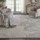 Living room scene with the Nourison Silk Shadows Sand modern rug, gray sofa, and natural light.