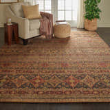 Living room scene with Nourison Jewel Blue Red Moroccan rug, beige armchair, and woven ottoman.