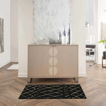 Modern entryway with a Nourison Grafix Black Bohemian rug, wood floors, and a light wood console table.