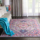 Living room scene with a Nourison Passion Light Grey Pink Bohemian Indoor Area Rug, sofa, and bright accents.