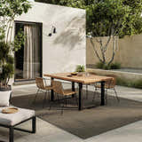 Modern patio with wood table and Nourison Horizon Charcoal rug. Outdoor living space.