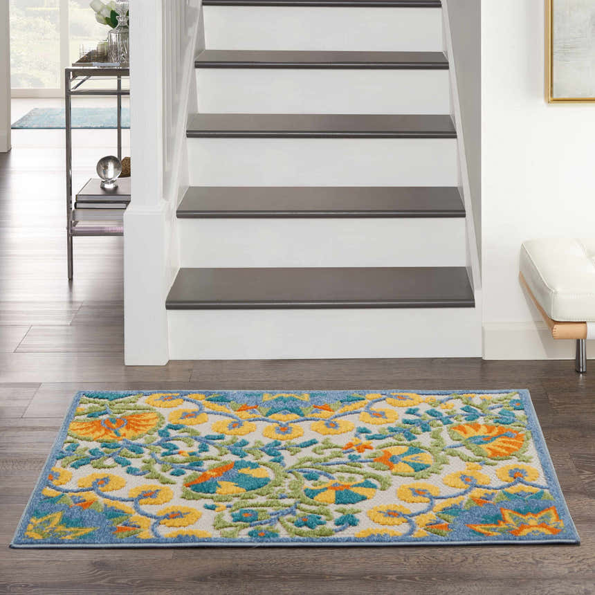 Entryway with Nourison Aloha Multicolor Transitional Area Rug, wood floors, white stairs, and modern decor.