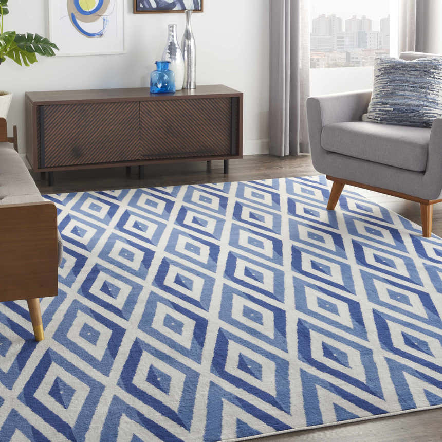 Modern living room with a Nourison Whimsicle Ivory Blue rug, gray armchair, and mid-century modern console table.