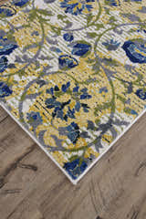 Close-up of Feizy Brixton Modern Scroll rug in ivory, gold, and green with a floral scroll pattern on hardwood floors. Corner