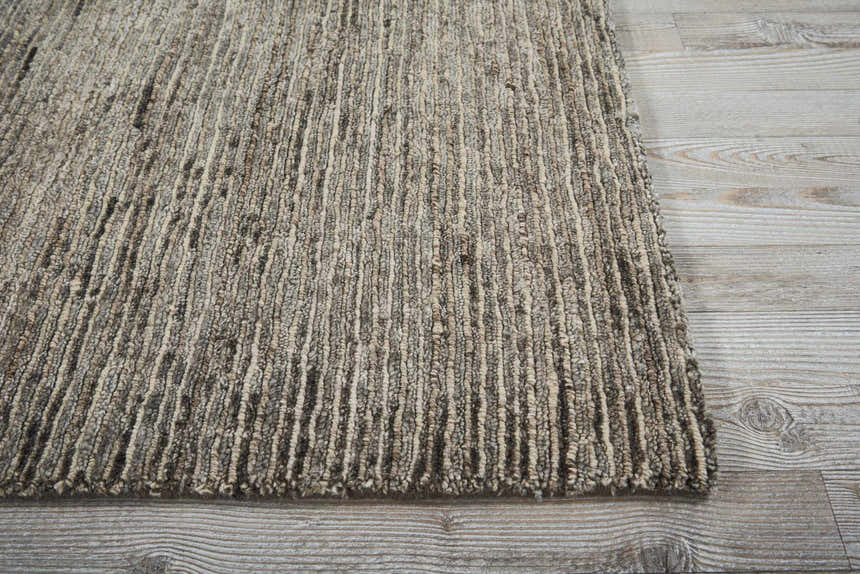 Close-up of the handmade Nourison OCEAN Sand area rug. The rug has a textured, striated design in sandstone colors.