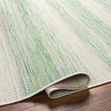 Close-up of the Kris Green Area Rug showing its woven texture and colors of dark beige, moss, and natural gray. Fold