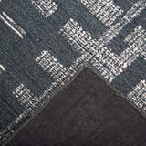 Close up of the hand-tufted Rizzy BX05BL area rug. Blue wool with ivory geometric pattern. Rug backing visible. Texture