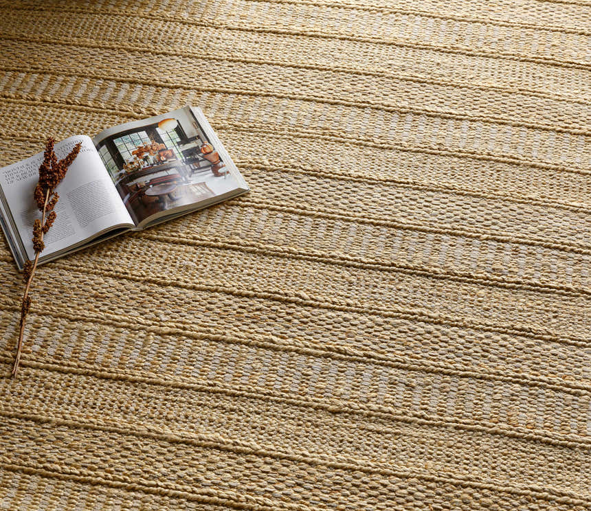 Close-up of the hand woven Bywong Area Rug. Beige and off white jute rug with a farmhouse, traditional, transitional style. Styleshot