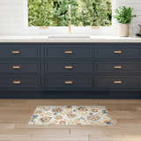 Farmhouse kitchen scene with Nourison Aloha Grey Multicolor rug, blue cabinets, wood floors, and garden view.