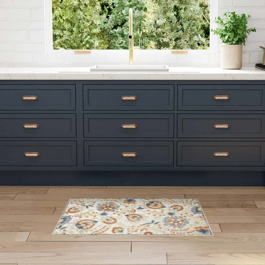 Farmhouse kitchen scene with Nourison Aloha Grey Multicolor rug, blue cabinets, wood floors, and garden view.
