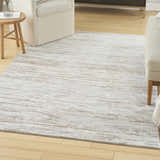 Living room scene with a Nourison Dew Silver Beige rug, cream furniture, and light wood floors.