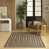 Living room scene with a brown leather chair and the Nourison Tulum Brown Outdoor Area Rug.