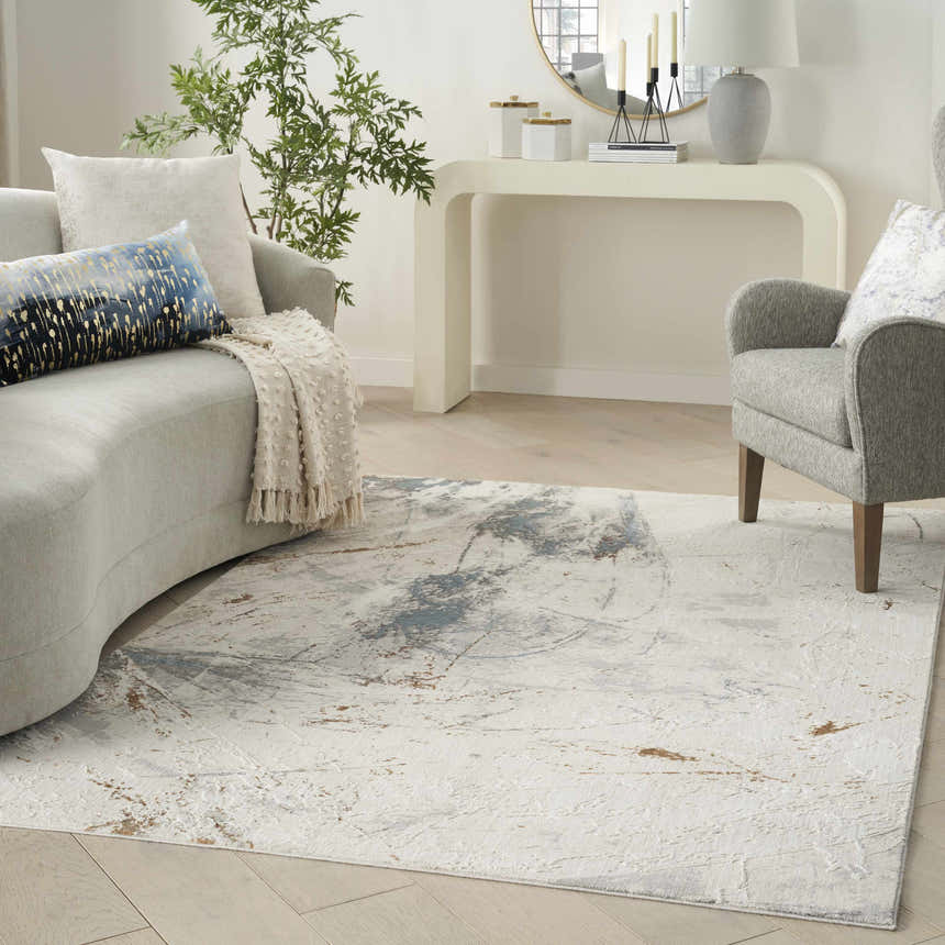 Living room scene with a Nourison Desire Ivory Grey Blue rug, sofa, chair, and white console table.