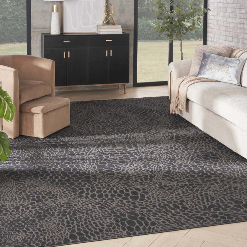 Living room scene with Nourison Desire Charcoal Silver rug, beige sofa and chair, and black cabinet.