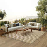Outdoor patio scene with a Nourison Positano Beige Ivory rug, sofas, wood table, and scenic mountain view.