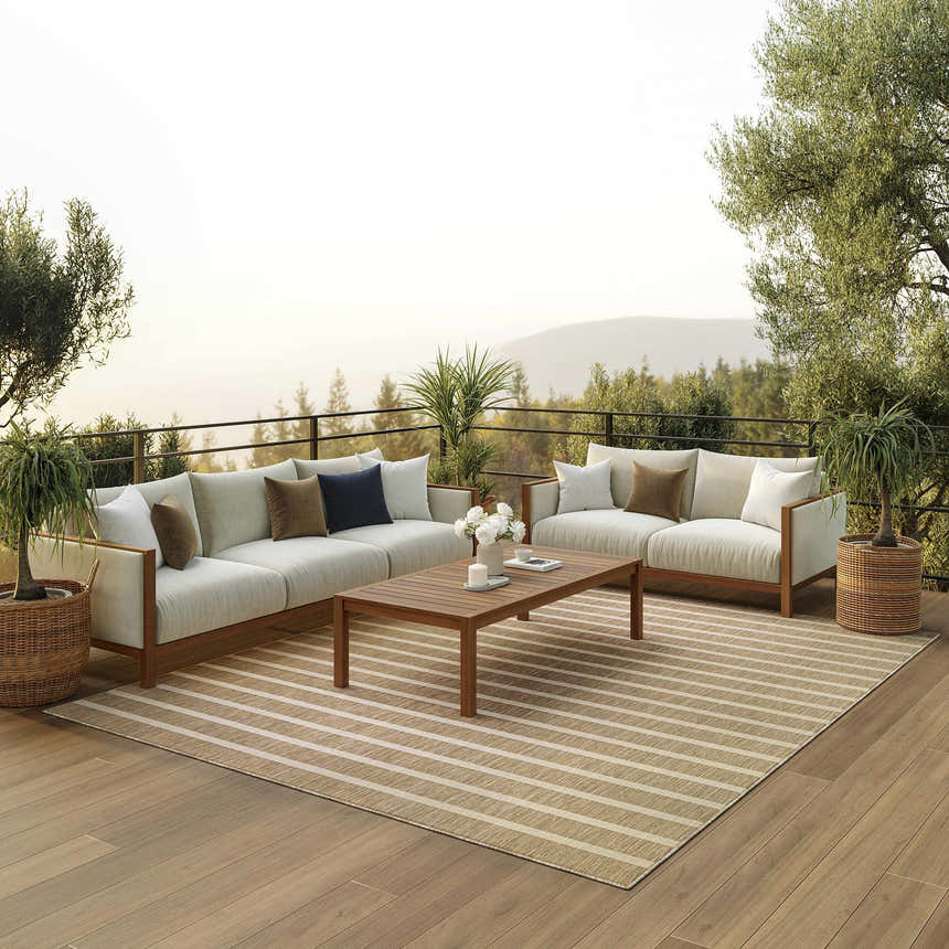 Outdoor patio scene with a Nourison Positano Beige Ivory rug, sofas, wood table, and scenic mountain view.