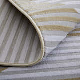 Close-up of Feizy Marigold rug showing gold, gray, and white geometric stripes and jute backing. Fold