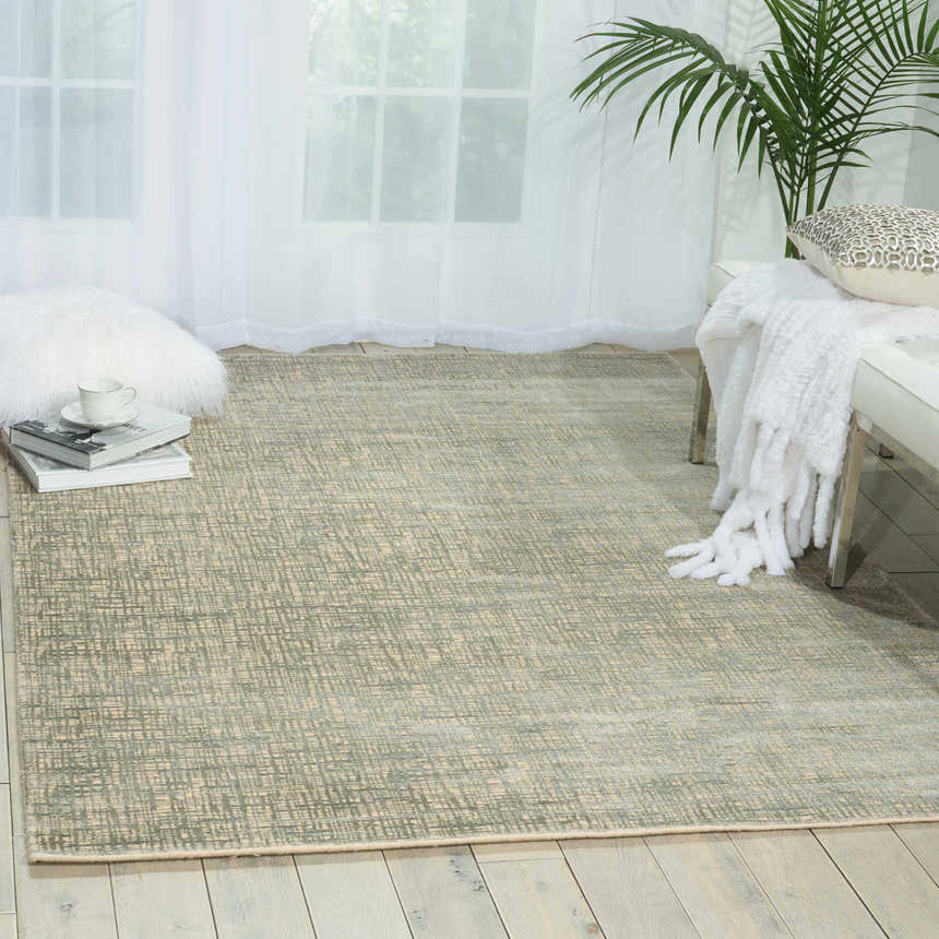 Light-filled room with a Sea Mist Nourison Starlight rug, white bench, and a palm for a modern, airy feel.