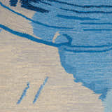 Close-up of the Nourison Symmetry Blue Ivory rug showing its abstract pattern and soft polyester texture.