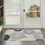 Entryway scene with a Nourison Aloha Blue Grey Modern Area Rug featuring a circular pattern in blue, gray, and white.