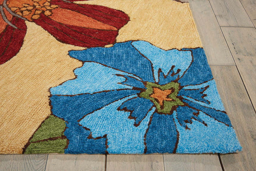 Close-up of the handmade Nourison South Beach Sand Area Rug. Features floral design in sandstone, blue, and rust colors.