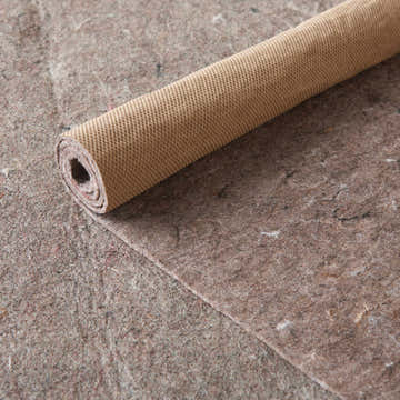 Close-up of the Nourison Loc Non-slip Pad Area Rug in silver gray, showing its texture and rolled form.