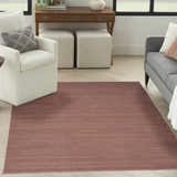 Living room scene with a Nourison Essentials Mocha rug, white chair, gray sofa, and wood desk.