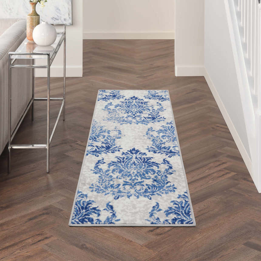 Hallway scene with Nourison Whimsicle Ivory Navy rug runner on dark wood floors, styled with a console table and neutral decor.