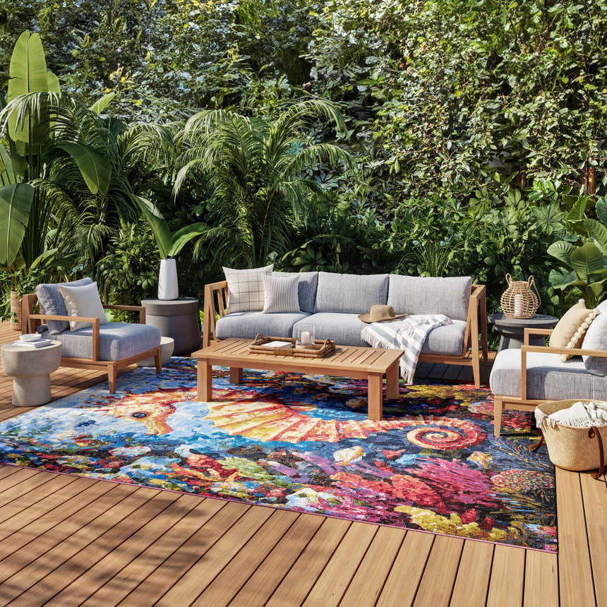 Outdoor patio with gray furniture and vibrant Nourison Color Splash rug. Nautical beach style with multicolor coral reef design.