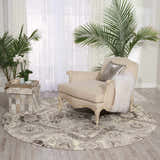Cozy reading nook with round Nourison Twilight Ivory Grey vintage rug, beige chair, and plants.