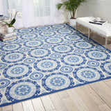 Bright living room with Waverly Sun N' Shade Navy Coastal Area Rug, white bench, wood floors, and natural light.