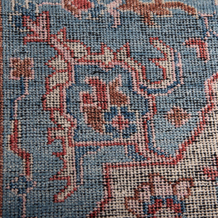 Close-up of the hand-knotted Rizzy CET723 area rug. Features a traditional pattern in beige, blue, dark red, and ivory wool. Texture