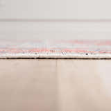 Close-up of the hand-knotted Rizzy CET723 area rug showing its texture, beige base, and dark red and blue pattern. Pile