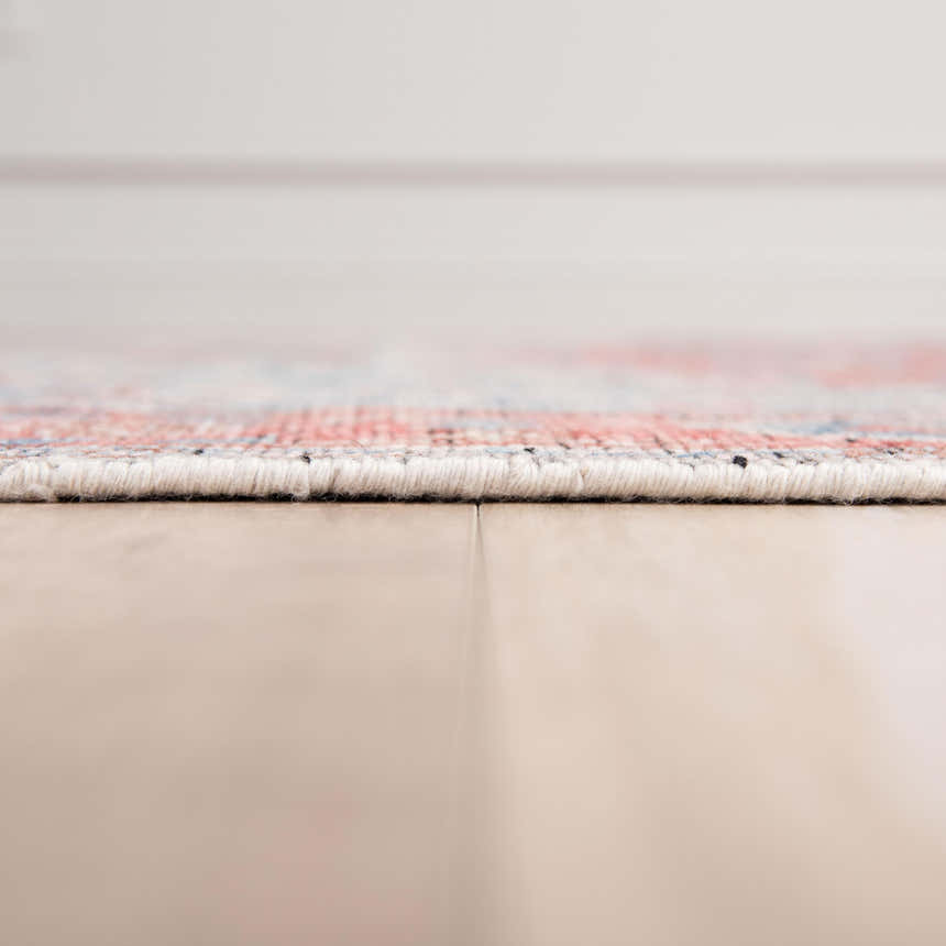 Close-up of the hand-knotted Rizzy CET723 area rug showing its texture, beige base, and dark red and blue pattern. Pile
