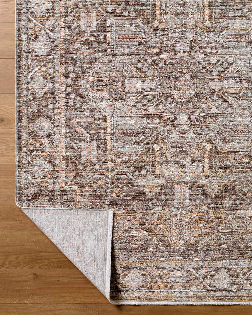 Close-up of the Clovia Area Rug showing its traditional black, gray, ivory, and brown pattern and texture on wood floor. Fold