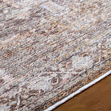 Close-up of the Clovia Area Rug showing its black, gray, ivory, and brown traditional pattern and soft texture. Texture