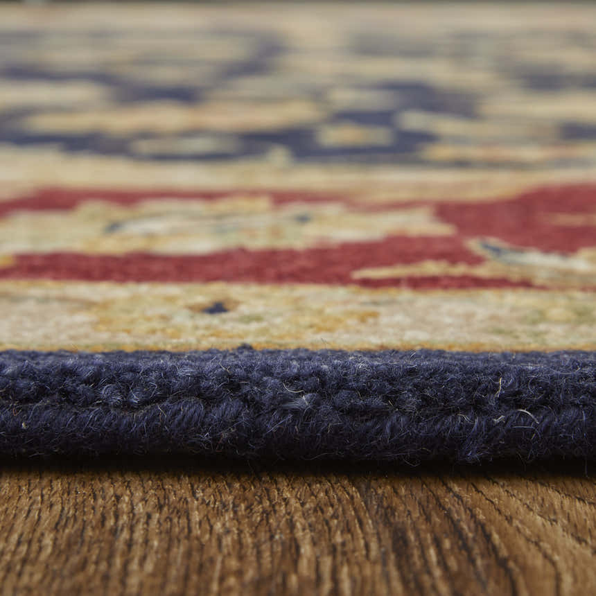Close-up of the Feizy Wagner rug showing wool texture, blue edge, and traditional red and gold pattern. Pile
