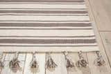 Close up of the Nourison Rio Vista ivory and grey striped wool rug with tassels.