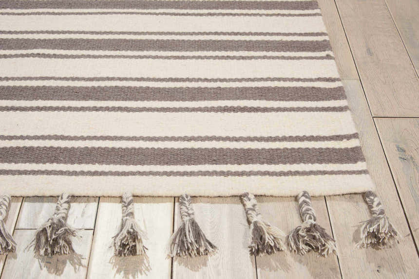 Close up of the Nourison Rio Vista ivory and grey striped wool rug with tassels.