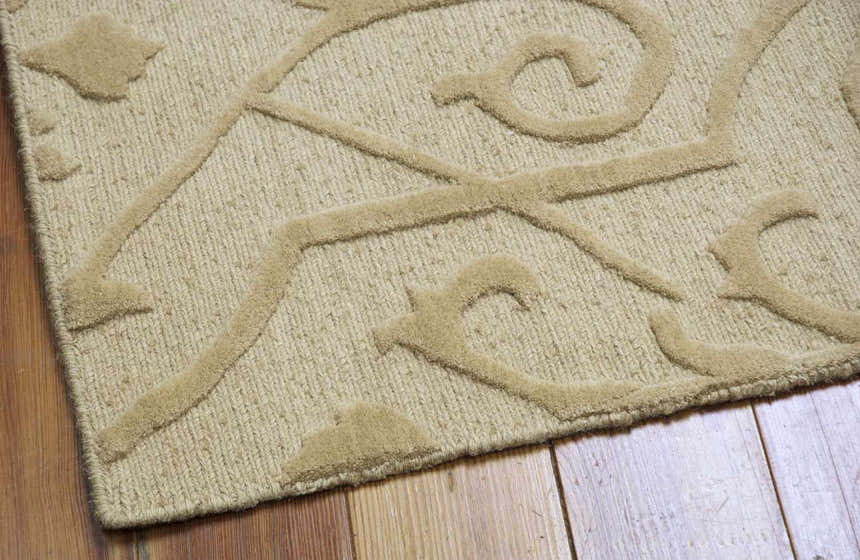 Close-up of the Nourison Ambrose Straw Indoor Area Rug, a tan wool rug with a raised geometric and floral design.