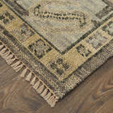 Close-up of Feizy Fillmore Traditional Diamond rug in brown and gray with tassels on a wood floor. Corner