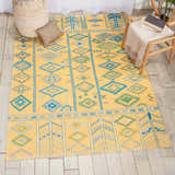 Living room scene with the Nourison Madera Saffron rug. Mustard rug features a tribal design with blue and green geometric patterns.