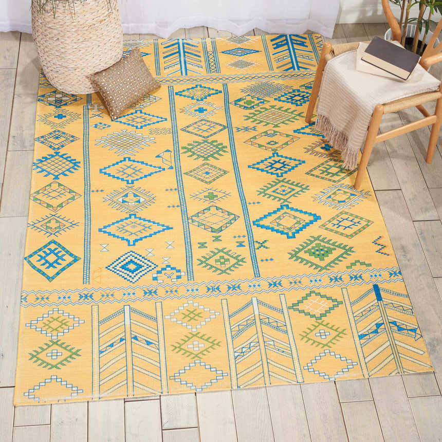 Living room scene with the Nourison Madera Saffron rug. Mustard rug features a tribal design with blue and green geometric patterns.