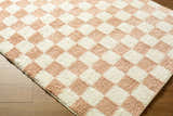 Close-up of the Bilshivtsi Area Rug. Features a textured, cream and light pink checkerboard pattern. Contemporary style. Corner